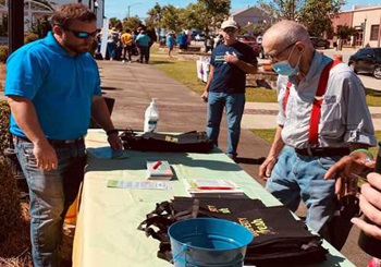 2 men talking at a table at festival